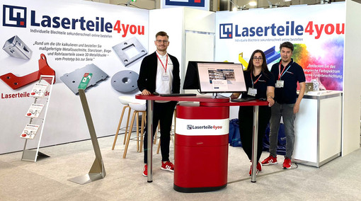 Drei Mitarbeiterinnen und Mitarbeiter an einem Laserteile4you-Messtand
