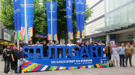Gruppenfoto der H.P. Kaysser LernFabrik Auszubildenden vor dem Stuttgart EM-Schriftzug