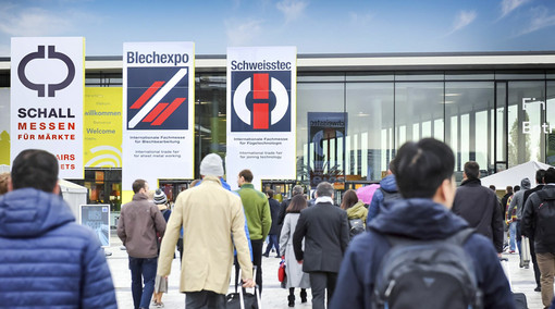 Menschen gehen auf den Eingang des Messe Stuttgart zu