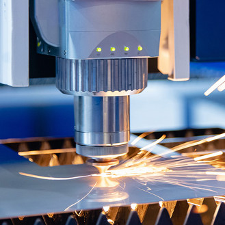Detailfoto einer Laserschneidanlage die gerade Metall zuschneidet
