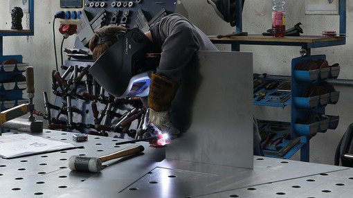 Mitarbeiter schweißt Bauteil per Hand