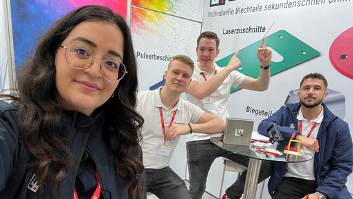 Gruppenfoto von 4 Mitarbeiterinnen und Mitarbeitern auf dem Laserteile4you Messestand