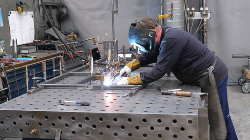 Mitarbeiter schweißt Gestänge per Hand