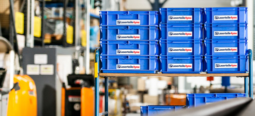 Gestapelte Laserteile4you Auftragskisten im Hochregallager