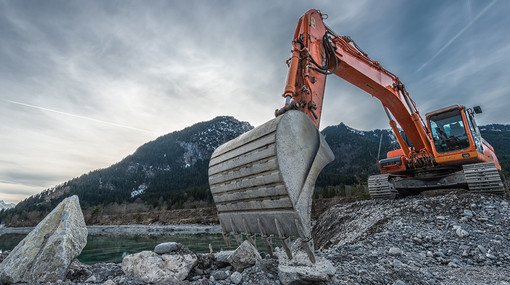 Bagger bei der Arbeit auf einem Steinhaufen